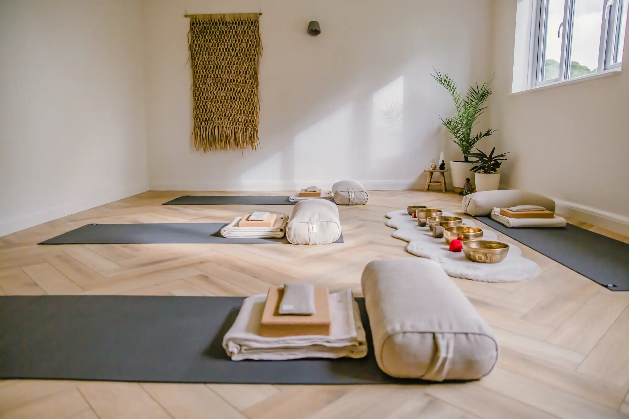 Yoga mats, bolsters and singing bowls laid out in the BluVeda studio